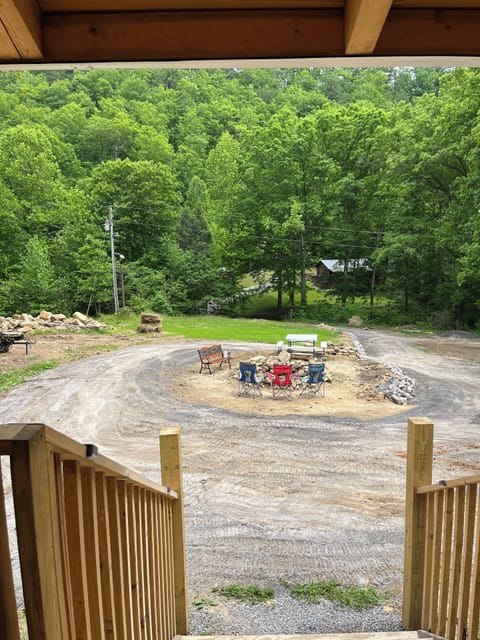 Front porch view of campfire pit and picnic area.