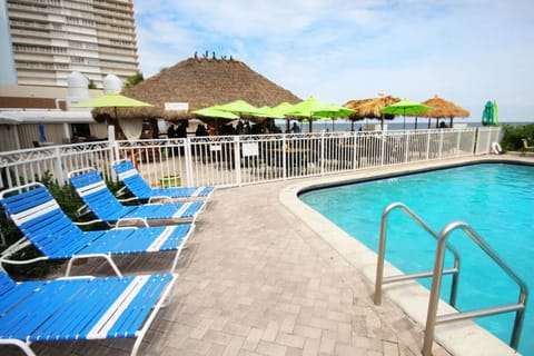 Lounge in comfort steps from sparkling water and shaded seating.
