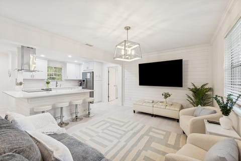 Unwind in the spacious, open-concept living room featuring comfortable seating, a Smart TV, and abundant natural light.