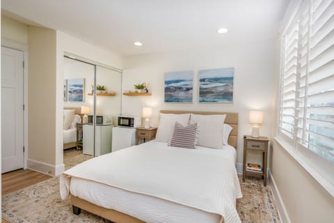 Modern bedroom, stylish Airbnb, cozy retreat, natural light, comfortable bed, beach-inspired, minimalist design, spacious room vacation rental, guest-friendly space, luxury stay, elegant, furnishing, relaxing ambiance, bright and airy.
