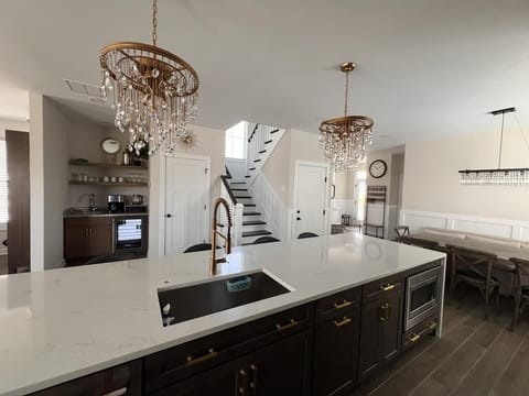 Another angle of the gourmet kitchen, highlighting sleek countertops and stylish lighting fixtures.