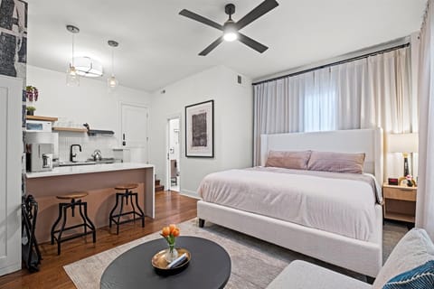 Bright and airy studio layout featuring a comfortable king bed, modern finishes, and an open flow into the full kitchen.