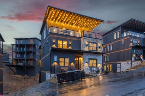 Side-angle rooftop shot at dusk with glowing lights.