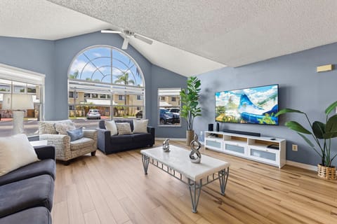 📺 Bright & Relaxing Lounge Space – Enjoy movie nights on the smart TV in this sun-filled living room with vaulted ceilings and large arched windows that bring the outdoors in. #SmartTV #NaturalLight #FamilyTime