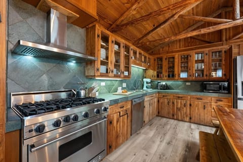 Fully equipped kitchen at Sunrise Lodge on Lake Travis with Viking stove, dishwasher, KitchenAid mixer, and rustic wood cabinetry, ideal for preparing meals during your family or group stay.