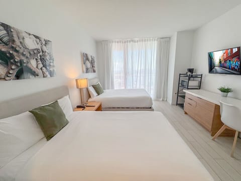 Bright room with two comfortable beds and outdoor views.