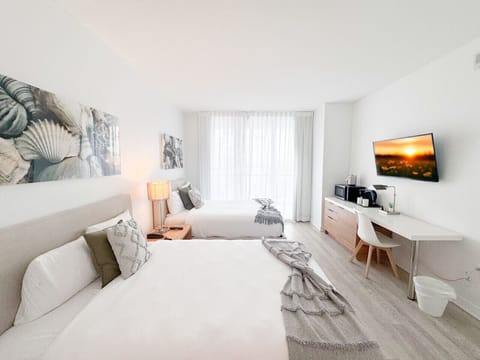 Spacious bedroom with balcony access and Smart TV.