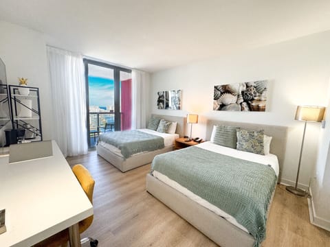 Spacious bedroom with balcony access and Smart TV.
