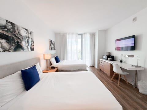 Bright and spacious bedroom with two double beds and natural light.