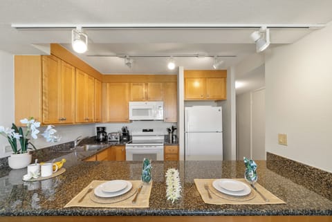 Modern kitchen featuring polished granite countertops, full‑size appliances, and warm wood cabinetry.