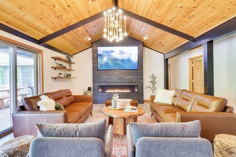 Stunning open layout living room with a cozy 7 ft real-flame gas fireplace.