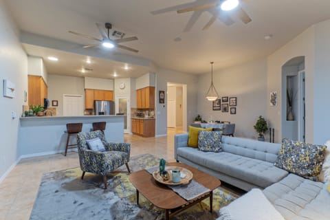 Fully stocked kitchen opens into great room with comfortable furnishings and a dining table.