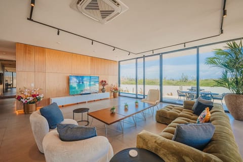 Floor-to-ceiling glass doors fill the living space with natural light and connect seamlessly to the outdoor lounge.