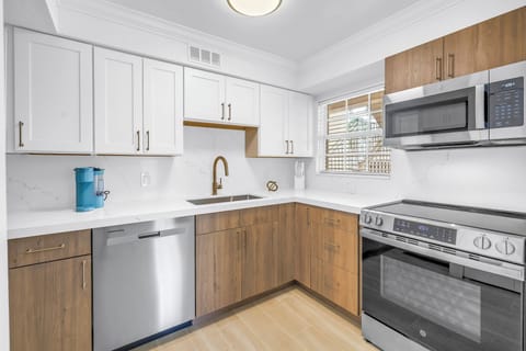 Fully equipped kitchen with stainless steel appliances, quartz countertops, and sleek cabinetry. Perfect for cooking at your Siesta Key getaway.