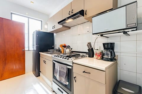 Bright kitchen showcasing stove, oven, and coffee accessories ready for use.