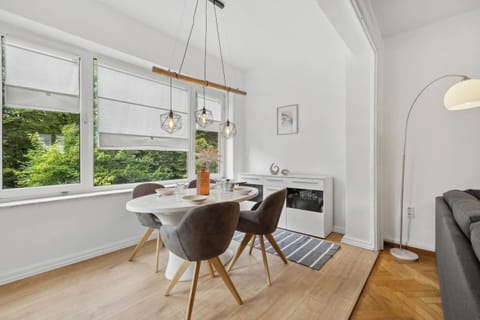 Helles Esszimmer mit modernem Design und Ausblick ins Grüne.