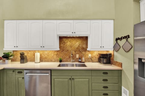 Fully stocked kitchen with deep sink and dishwasher.