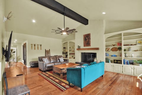 Open concept living room with 2 couches,  fireplace and large flat screen TV.  
