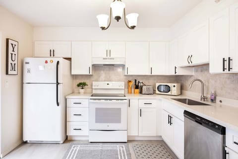 Spacious kitchen area featuring a stylish backsplash, high-end appliances, and a well-equipped counter with everything you need to enjoy your stay.
