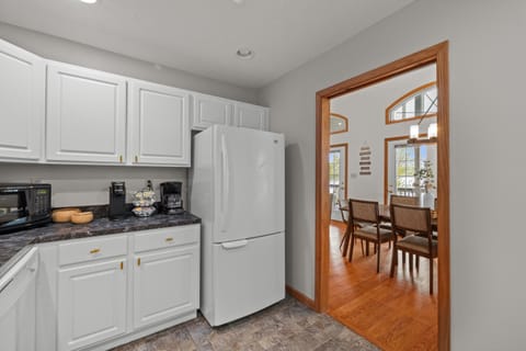 Fully stocked kitchen with white appliances, stainless sink, dishwasher, microwave, toaster, and coffee maker.