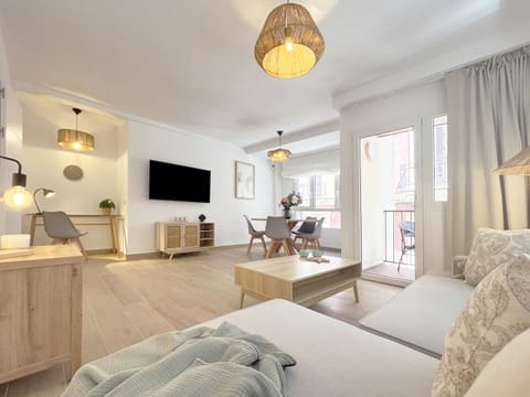 Bright living-dining room featuring a Nordic design aesthetic. This spacious area integrates a comfortable seating zone, a functional dining area, and direct access to an outdoor balcony.