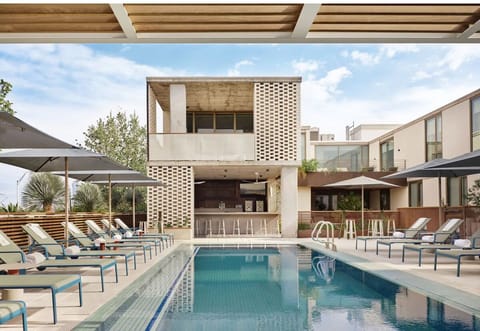 Unwind poolside on sleek loungers in a sunny courtyard escape