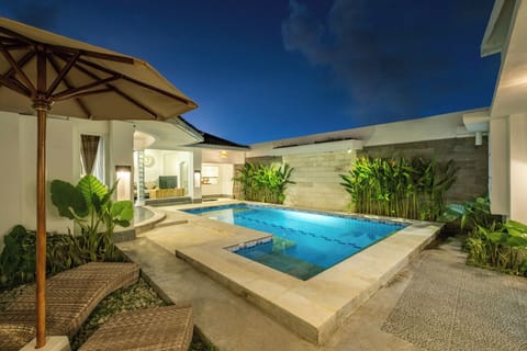 Sun loungers and shaded area beside the pool at Villa Lalebay