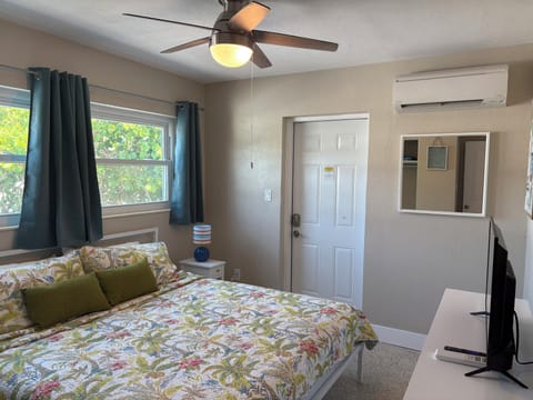 Bedroom 1 with king bed and sheets, exterior door 