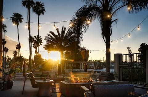 Lounge comfortably outdoors with warm lighting and cozy fire tables.