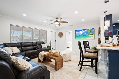 Spacious open-concept living room with a plush sectional sofa, smart TV, and modern décor — the perfect spot to relax after a day at the beach