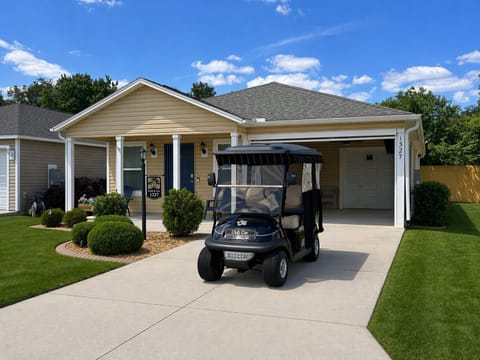 Front of home with screened in lanai and golf cart for guest use.