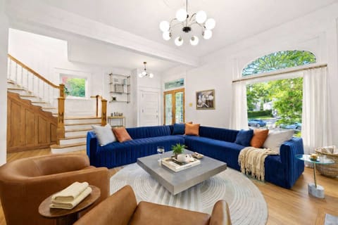 Living Room: Indulge in the vibrant elegance of our spacious living room, featuring a plush, oversized blue velvet sectional perfect for relaxing after exploring the city's charm.