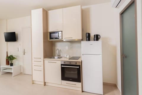 Compact Kitchen with Oven & Espresso Machine
Fully equipped kitchen featuring oven, stove, fridge, and coffee-making essentials.