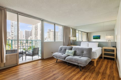 Wake to stunning city views through floor-to-ceiling windows in your modern bedroom with private balcony access.