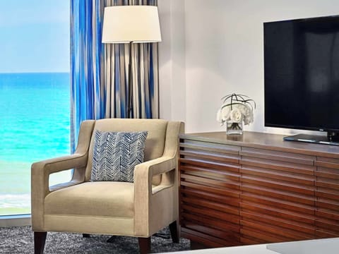 Unwind in a cozy chair with TV and sea views.