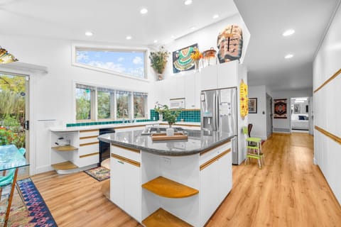 Bright and spacious kitchen with skylights, modern appliances, and a large central island for group cooking.