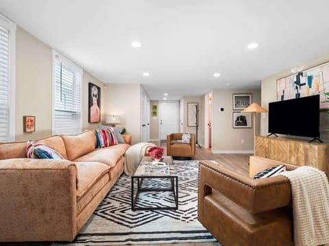 Inviting living room w/ plush seating, patterned rug & TV for relaxed movie nights