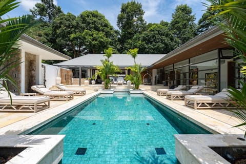 Sparkling private pool surrounded by lush tropical gardens and villa pavilions