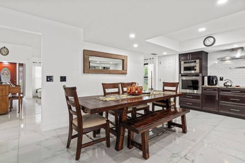 The fully equipped kitchen features a top oven, microwave, large fridge, and beautiful dinning table