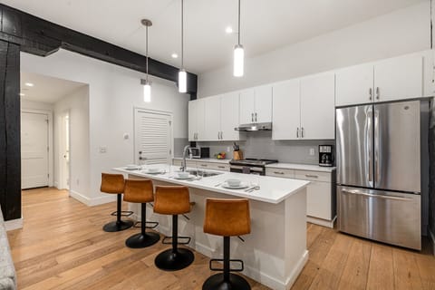 Unit 2: Open-concept living area featuring cozy furnishings, smart TV, small dining area with seating for 2 guests, and a sleeper sofa.