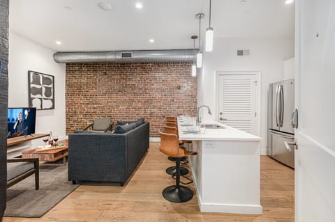 Unit 1: Open-concept living area featuring cozy furnishings, smart TV, and a sleeper sofa.