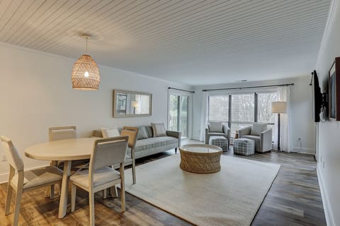Living area with flatscreen tv, comfortable couches, and a dining table featuring 4 chairs.