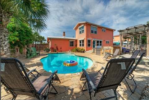 Relaxing poolside seating area with vibrant house exterior.