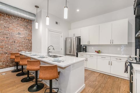 Unit 3: Fully equipped kitchen featuring stainless steel appliances, open counter space, and bar seating for 5 guests.