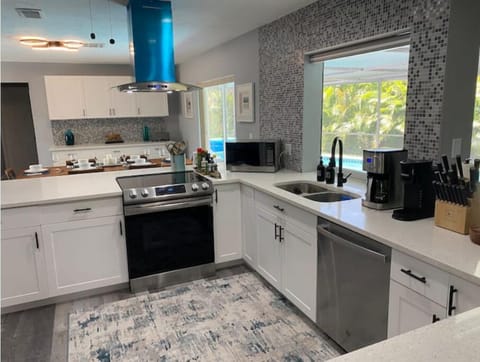 Open kitchen with Samsung, stove, oven, dishwasher, refrigerator and range hood