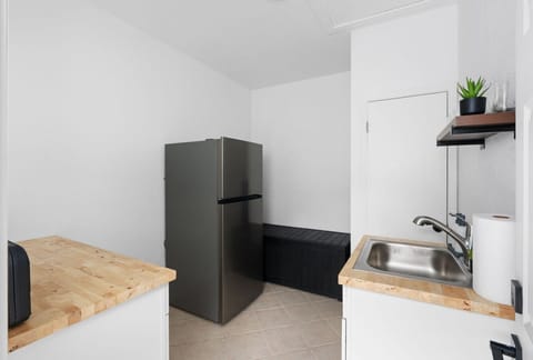 Convenient kitchenette space with full-size fridge, prep counters, and sink—ideal for storing snacks or preparing light meals during your stay