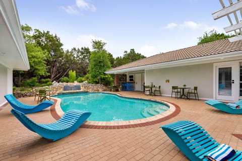 Relax in your own backyard paradise featuring a sparkling pool, waterfall feature, and plenty of loungers for sun-soaked days. Surrounded by nature and stylish outdoor seating, it’s the perfect spot to unwind with family or friends.