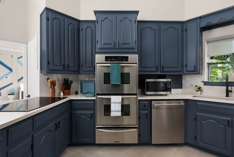 Fully equipped chef’s kitchen with sleek stainless steel appliances and stylish navy cabinetry—ideal for cooking up your favorite meals during your stay