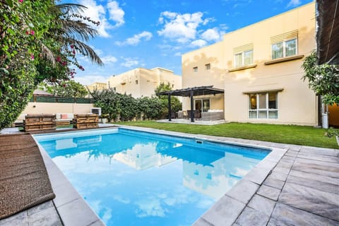 Outdoor Oasis: Dive into relaxation by the shimmering pool surrounded by lush greenery!