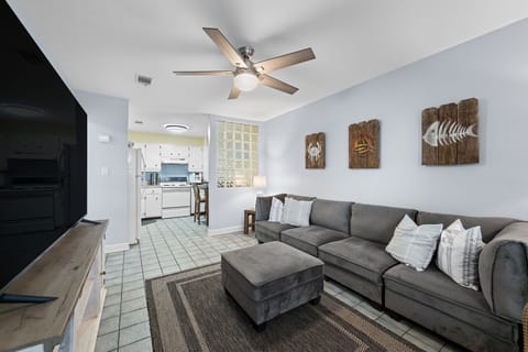 The spacious sectional sofa flows effortlessly into a fully equipped kitchen, ideal for entertaining or keeping an eye on dinner while lounging.